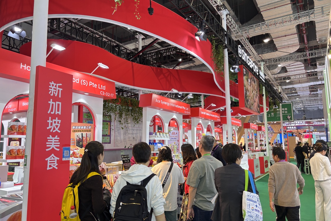 22家新加坡农食产品企业参加今年进博会,图为看展中国民众在一家美食摊位前驻足品尝。(黎康摄)