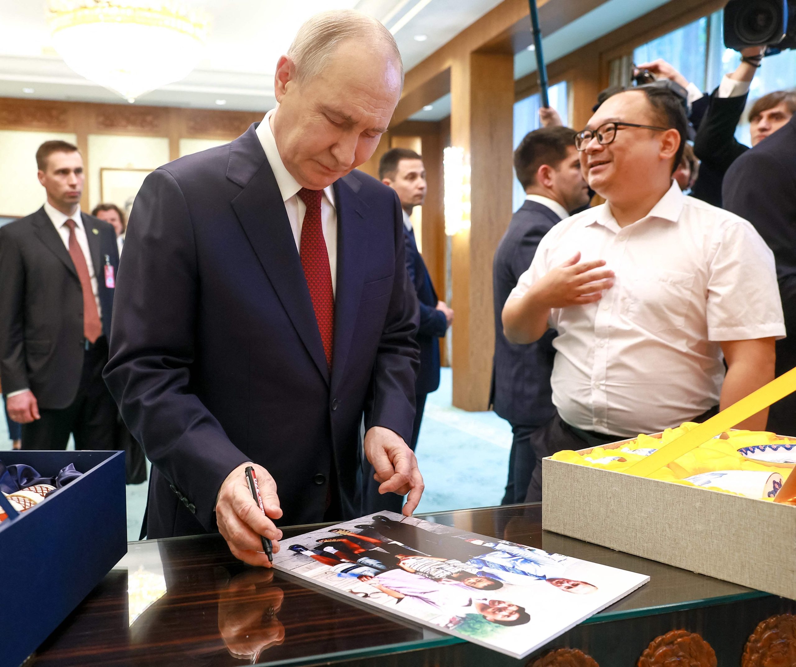 俄罗斯总统普京星期三(5月20日)在人民大会堂与26年前访华时在公园偶遇的中国男孩彭湃重逢,互赠礼物。(法新社)