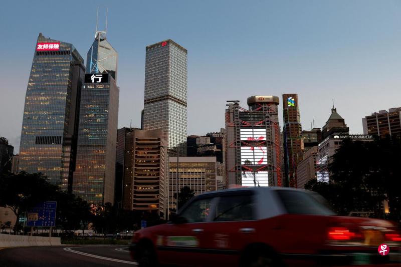 中国大陆科技公司掀起的人工智能(AI)热潮,正持续拉动对香港数据中心的需求。图为一辆出租车驶过香港中环商业区,背景可见友邦金融中心、中国建设银行大厦、中国银行大厦、长江集团中心,以及汇丰银行和渣打银行总部等摩天大楼。(路透社档案照片)